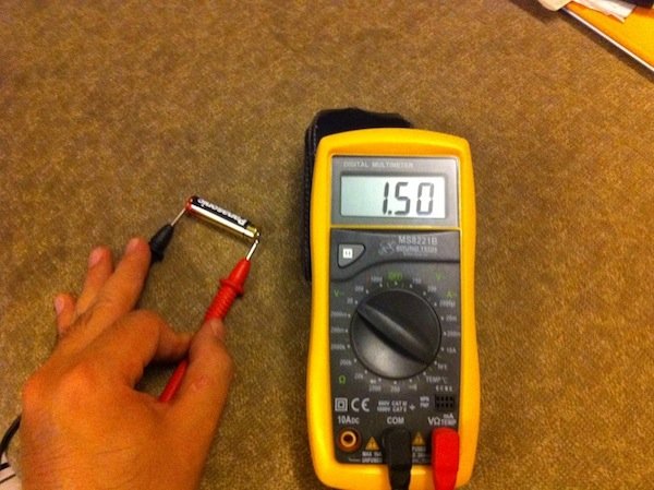 How do you test a battery with a multimeter?
