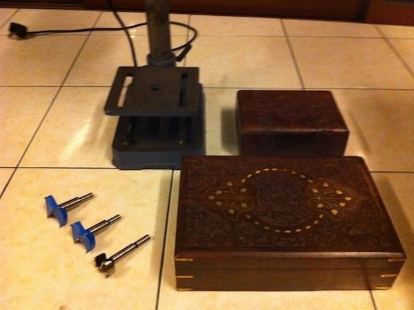 1. These are the main tools we will be using, to work on the wooden mahogany box. Shown here are one large and one small box, with 2 Forstner bits of different sizes and a metal hole saw, and a drill press. Ignore the small box for now.